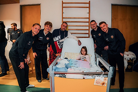 Tony Menzel, Jonas Oehmichen, Niklas Hauptmann und Henry Anschütz am Krankenhausbett eines kleinen Mädchens mit ihrem Vater.