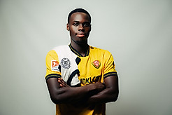 Kofi Amoako im Dynamo-Trikot mit einem Trikot der deutschen Nationalmannschaft über der Schulter.