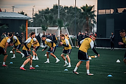 Die Spieler machen sich auf dem Rasen warm.