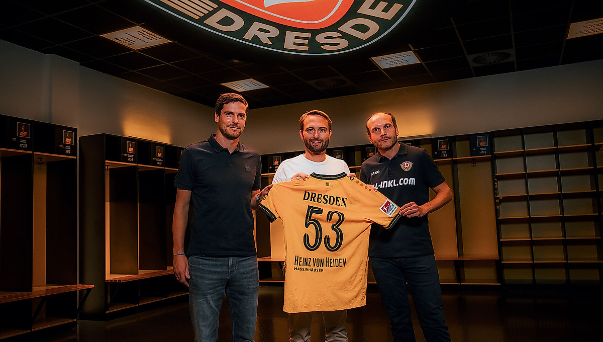 Maik Hägner (Abteilungsleiter SPORTFIVE), Dr. Helge Mensching (Geschäftsführer Heinz von Heiden GmbH Massivhäuser) und David Fischer (Geschäftsführer Kommunikation SG Dynamo Dresden) halten gemeinsam ein Trikot der SGD in der Heimkabine der Sportgemeinschaft. 