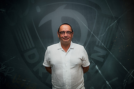 Steffen Illner vor dem Wappen der SGD.