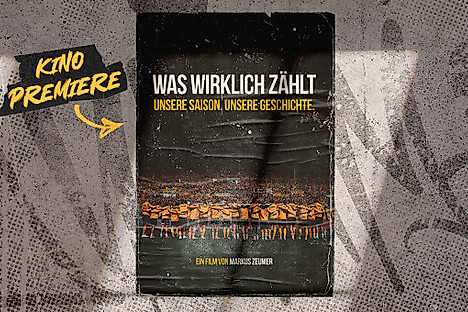 Filmplakat des Aufstiegsfilms Was wirklich zählt. Darauf abgebildet die Mannschaft mit dem Rücken zur Kamera vor dem Block.