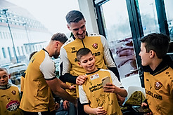 Ein Kinde macht ein Selfie mit Dynamo-Kapitän Stefan Kutschke