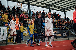 Fußballspieler laufen ins Stadion ein