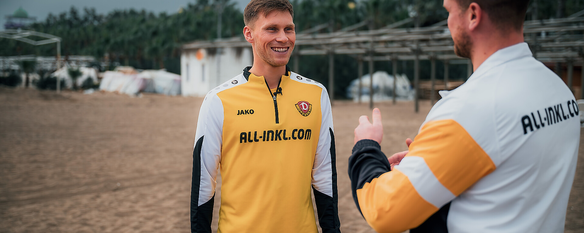 Zwei Menschen unterhalten sich am Strand.