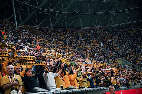 Die Fans der SGD mit erhobenen Schals im Rudolf-Harbig-Stadion.