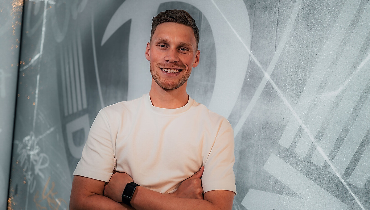 Jonas Sterner vor dem Wappen der SGD.