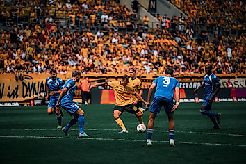 Jakob Lemmer holt im Rudolf-Harbig-Stadion zum Schuss aus. Im Vordergrund sind vier Magdeburger Spieler zu sehen.