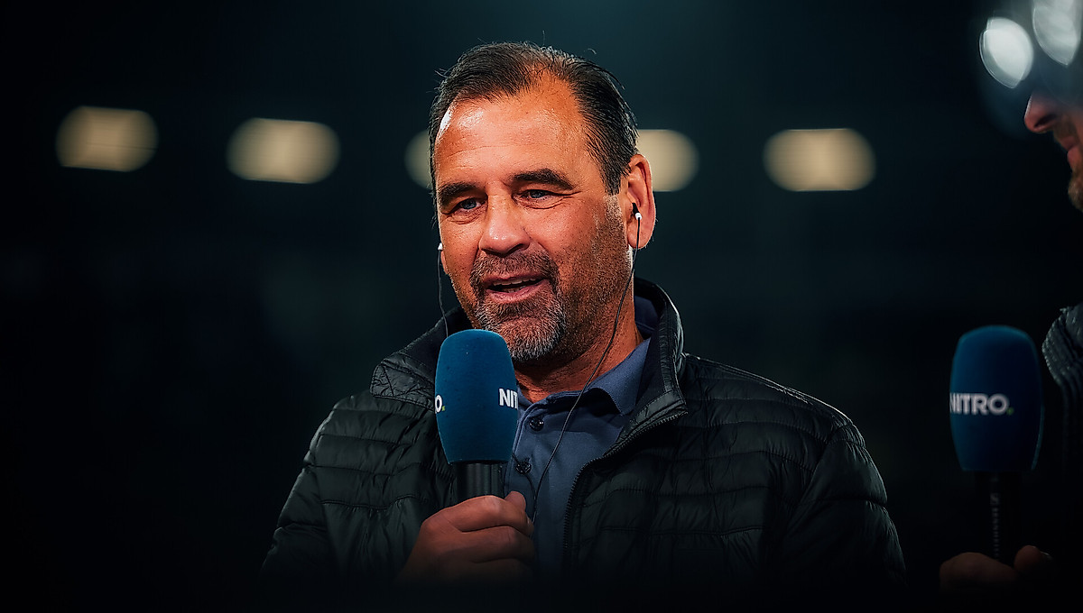 Ulf Kirsten mit einem Mikrofon in der Hand.