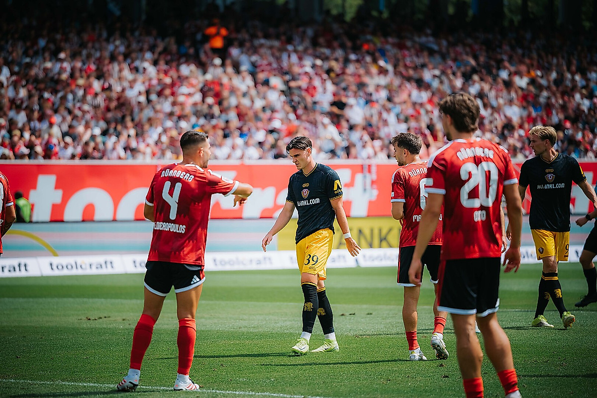 Thomas Keller zwischen Spielern des 1. FC Nürnberg