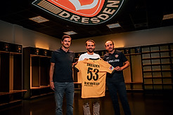 Maik Hägner (Abteilungsleiter SPORTFIVE), Dr. Helge Mensching (Geschäftsführer Heinz von Heiden GmbH Massivhäuser) und David Fischer (Geschäftsführer Kommunikation SG Dynamo Dresden) halten gemeinsam ein Trikot der SGD in der Heimkabine der Sportgemeinschaft. 