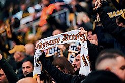 Ein Dynamo-Fan hält im RUdolf-Harbig-Stadion seinen Schal in die Höhe.