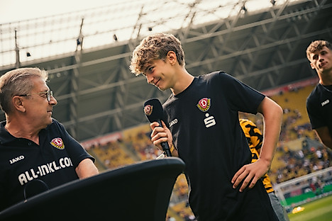Dmytro Tsebeniak mit einem Mikro in der Hand beim Gespräch im Stadion mit Stadionsprecher Peter Hauskeller.