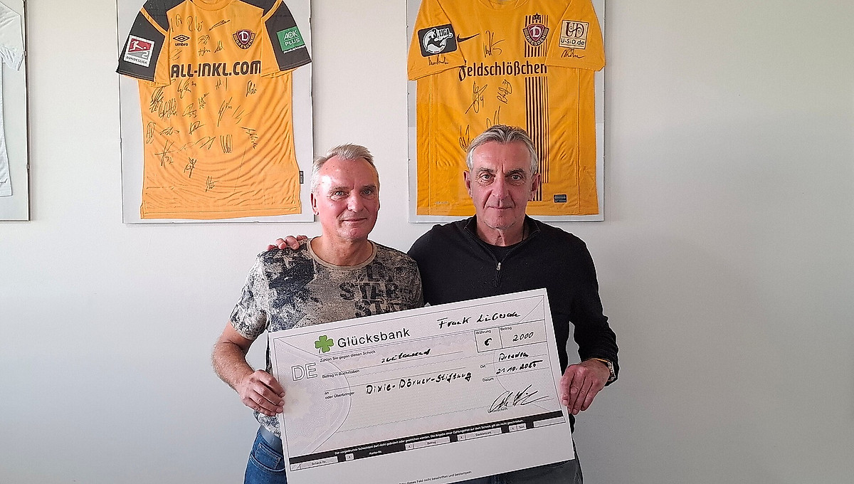 Zwei Menschen halten einen großen Scheck in der Hand.