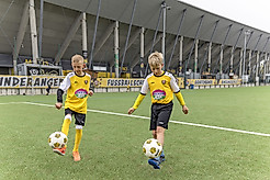 Zwei Jungs halten mit dem Fuß einen Ball hoch