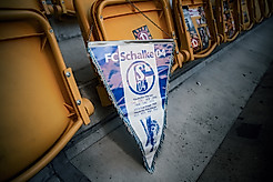 Ein Wimpel des FC Schalke 04 hängt an der Sitzschale im Rudolf-Harbig-Stadion.