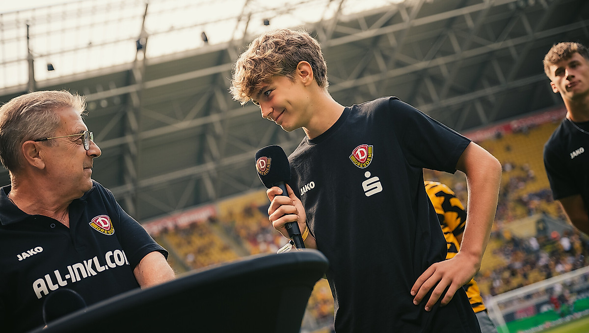 Dmytro Tsebeniak mit einem Mikro in der Hand beim Gespräch im Stadion mit Stadionsprecher Peter Hauskeller.