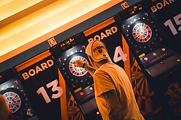 Ein Dynamo-Fan wirft einen Pfeil auf eine Dartscheibe.