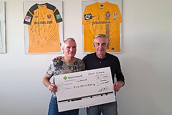 Zwei Menschen halten einen großen Scheck in der Hand.