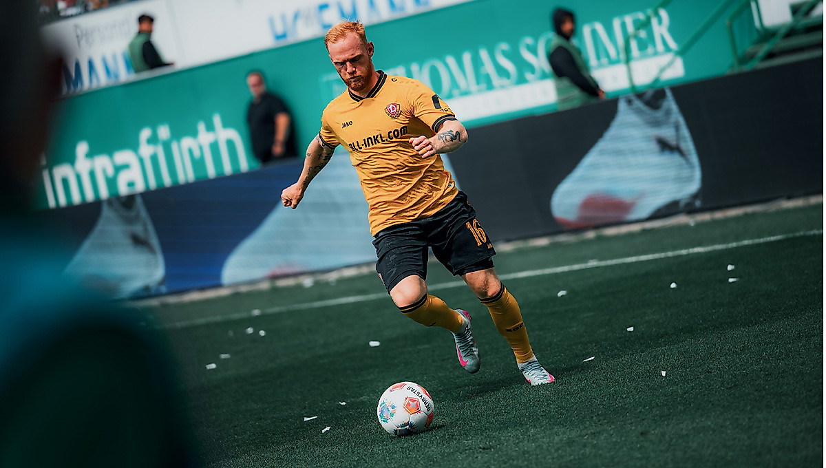 Dynamos Mittelfeldspieler Nils Fröling im gelben Heimtrikot als er eine Flanke beim Auswärtsspiel in Fürth schlägt.