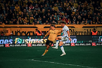 Jakob Lemmer im Zweikampf mit einem Karlsruher Gegenspieler. Lemmer holt zum Schuss aus, der Ball ist vor ihm in der Luft