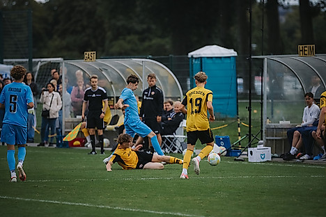 Dynamos Nachwuchsspieler grätscht Richtung Ball.