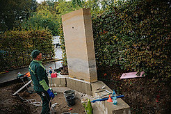 Ein Bauarbeiter vor einer Sandstein-Tafel