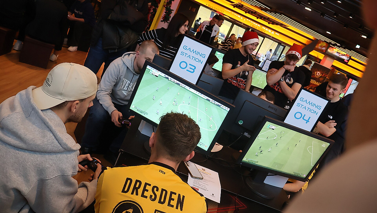 Teilnehmer, die beim Turnier vor der Konsole sitzen und EA FC spielen.