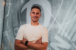 Jonas Sterner vor dem Wappen der SGD.