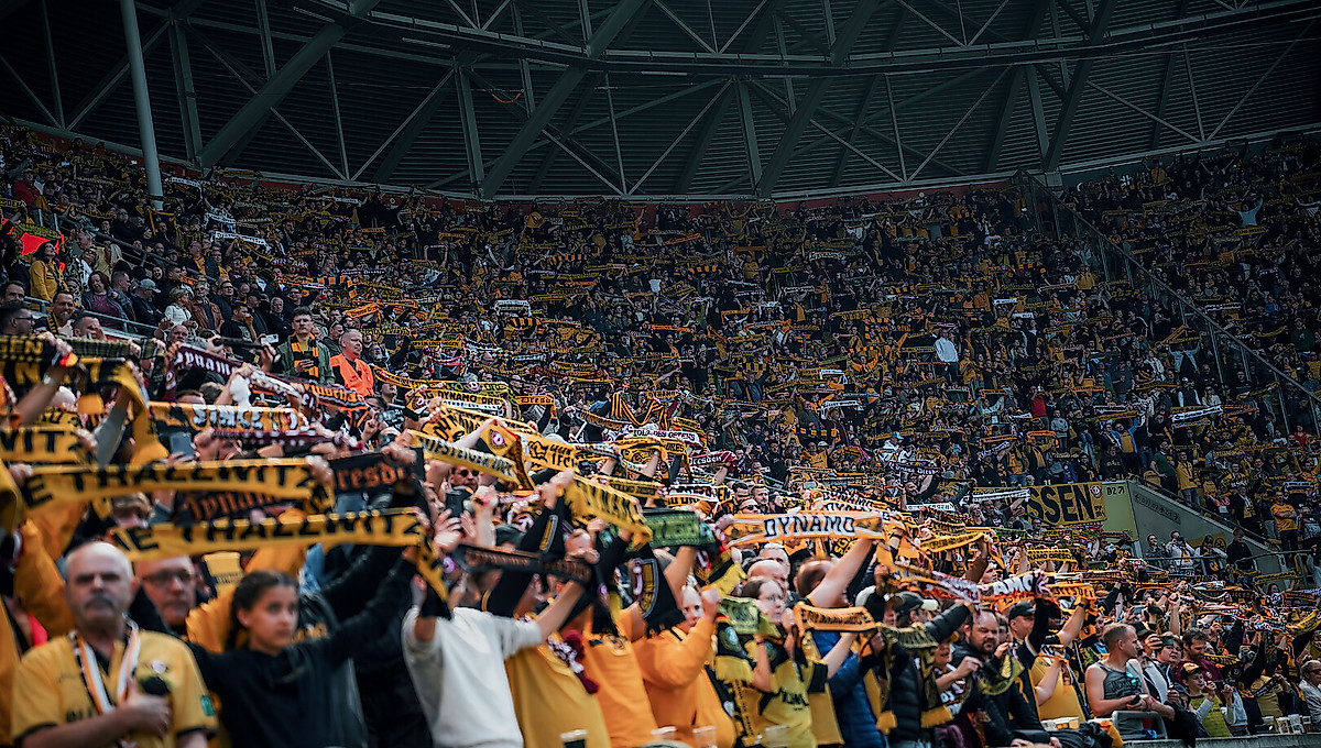 Die Fans der SGD mit erhobenen Schals im Rudolf-Harbig-Stadion.
