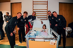 Tony Menzel, Jonas Oehmichen, Niklas Hauptmann und Henry Anschütz am Krankenhausbett eines kleinen Mädchens mit ihrem Vater.