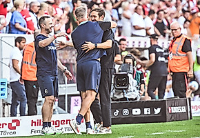 Schuster embraces (Lars Voßler and Patrik Grolimund, left) after beating Stuttgart on the opening day.