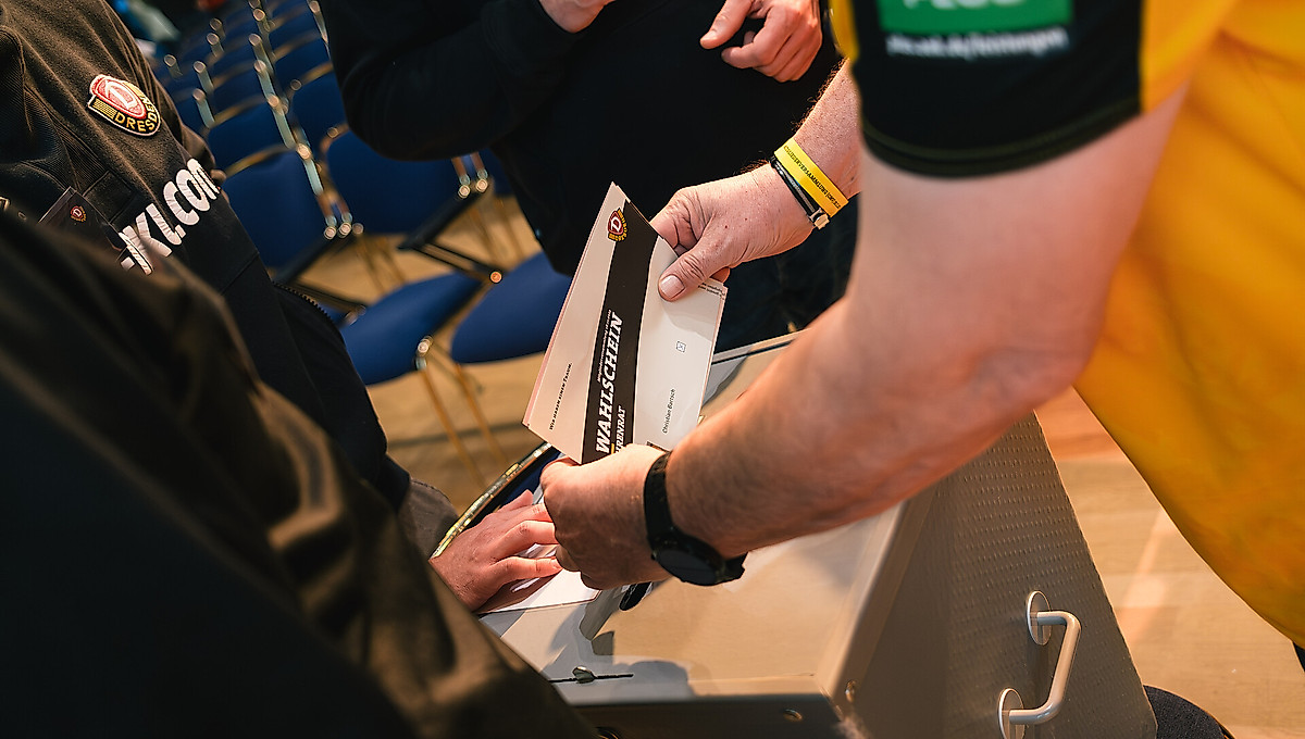 Ein Dynamo-Fan wirft einen Wahlzettel in eine Urne.