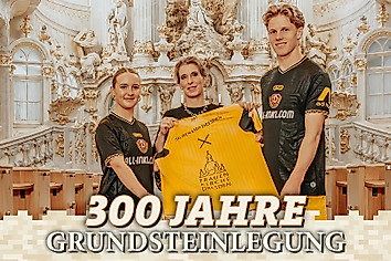 Drei Personen präsentieren in einer Kirche ein Fußballtrikot - darunter der Text 300 Jahre Grundsteinlegung