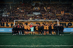 Mannschaft und Staff der SGD halten im Tor vor dem K-Block ein Trikot von Torhüter Lennart Grill hoch..