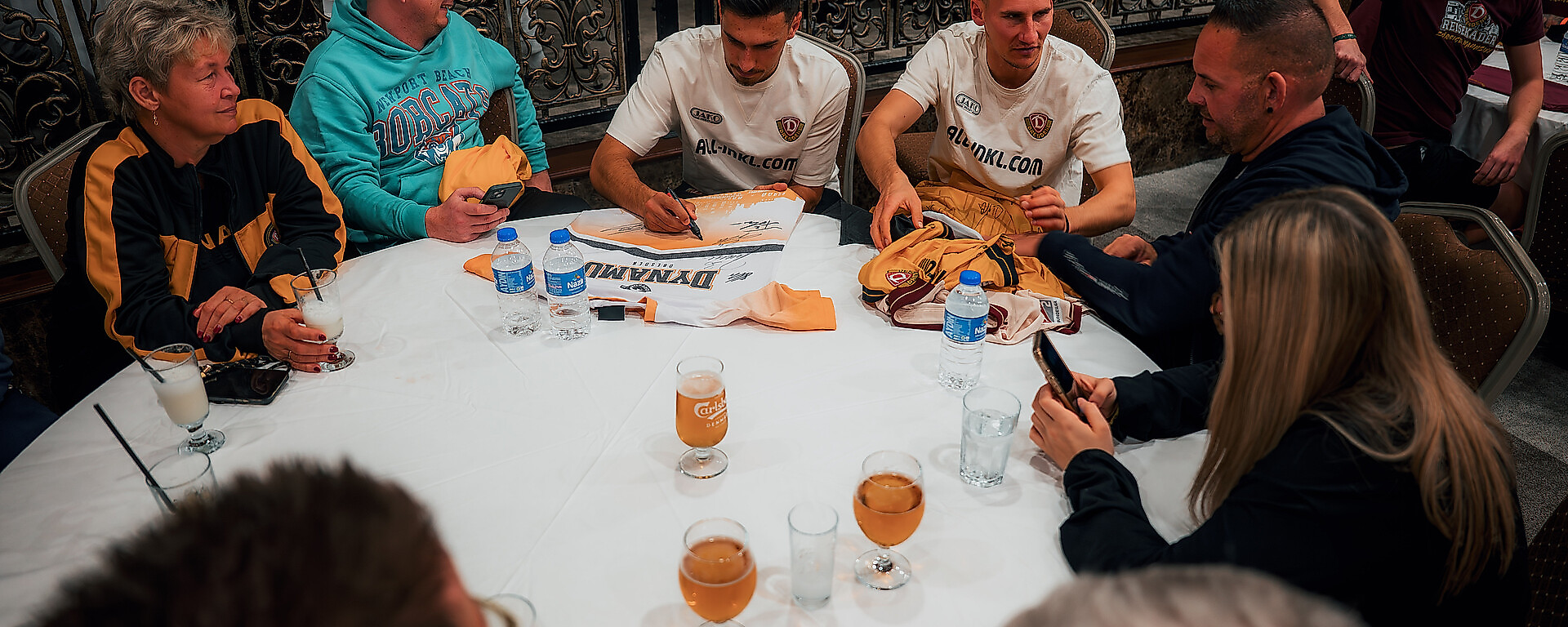 Fans und Spieler unterhalten sich an einem Tisch