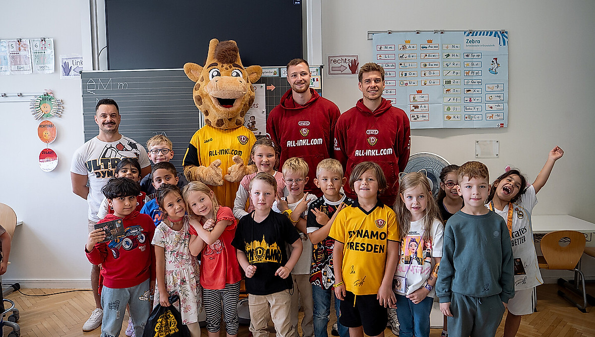 Eine Schulklasse beim Gruppenbild mit Spielern der SGD