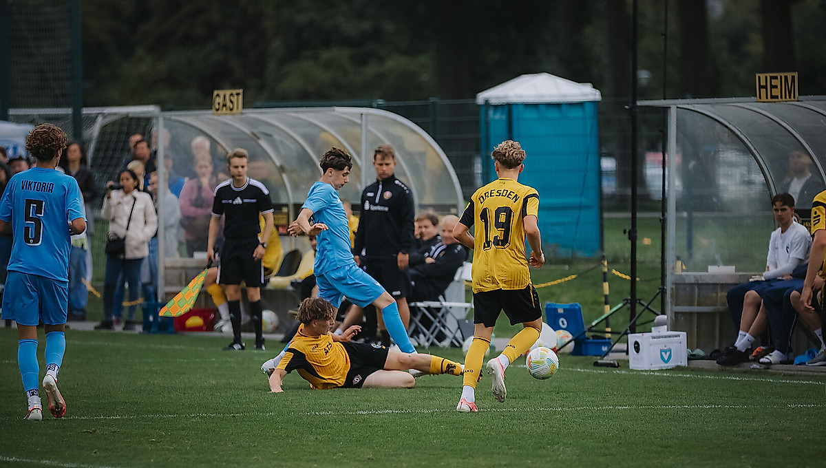 Dynamos Nachwuchsspieler grätscht Richtung Ball.