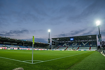 Das leere Kieler Holstein-Stadion bei eingeschaltetem Flutlicht.