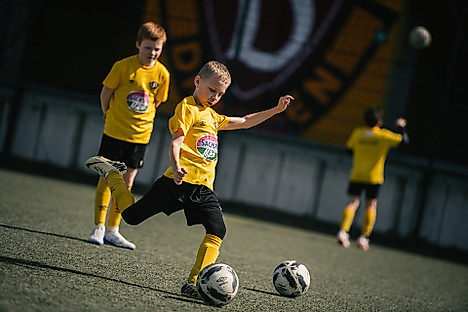 Ein Junge schießt einen Ball.