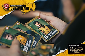 Ein Kind hält signierte Autogrammkarten in der Hand.