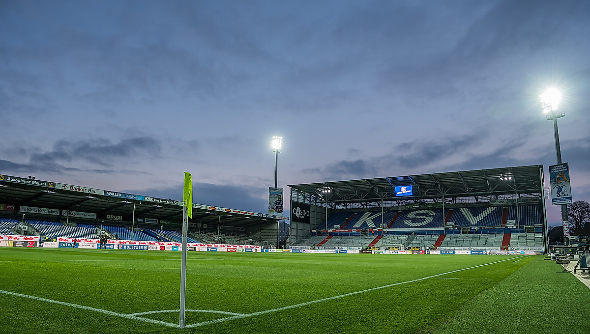 Das leere Kieler Holstein-Stadion bei eingeschaltetem Flutlicht.