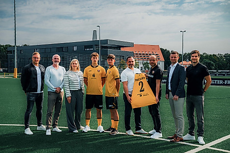 Die neuen Teampartner der U21 präsentieren das Trikot und die Hose der Spieler mit der Sponsorenwerbung.