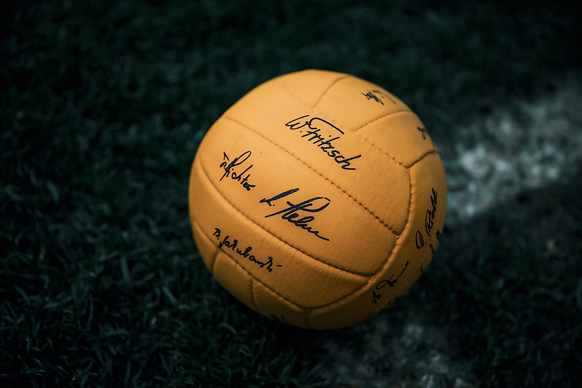 Ein gelber Ball mit schwarzen Unterschriften.