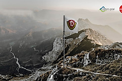 Fotomontage einer Dynamo-Eckfahne auf einem Berg der Alpen.