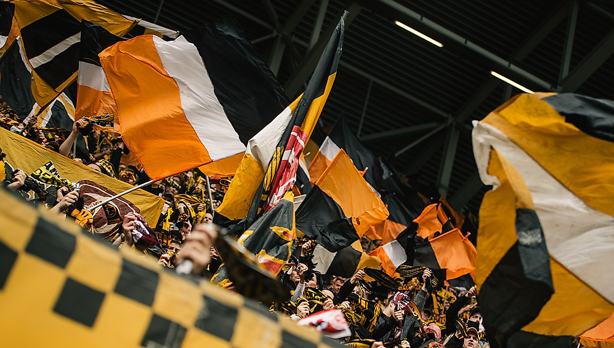 Wehende Fahnen und Schals der SG Dynamo Dresden im K-Block des Rudolf-Harbig-Stadions