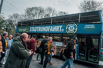Ein Bus der Dresdner Stadtrundfahrt mit wartenden Dynamo-Fans davor