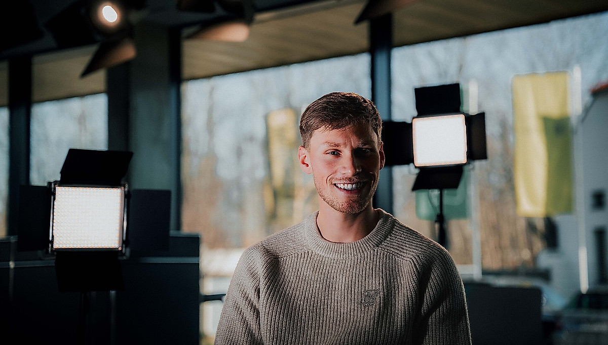 Jonas Sterner vor Scheinwerfern im Pressekonferenzraum.