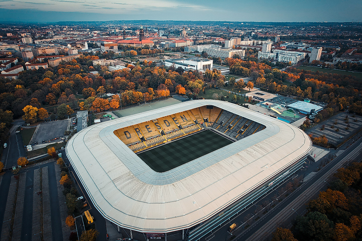 Das Rudolf-Harbig-Stadion aus der Vogelperspektive mit Stadtsilhoutte im Hintergrund.