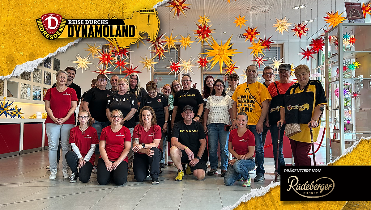 Eine Gruppe Menschen unter zahlreichen bunten Weihnachtssternen.